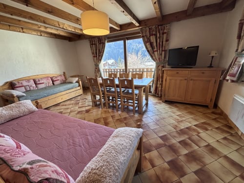 Spacious ski apartment with wooden beams, two beds, dining table, TV, balcony overlooking snowy mountains at Chez Francine