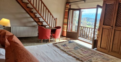 Amplia habitación doble de lujo con balcón en Hotel Mas D'En Roqueta, con vistas a las montañas y mobiliario elegante