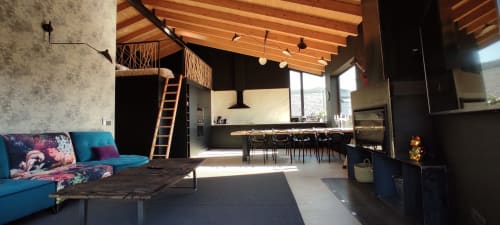 Acogedor interior de casa de campo con sofá azul, vigas de madera, cocina, comedor y vistas al jardín en Hotel Mas D'En Roqueta
