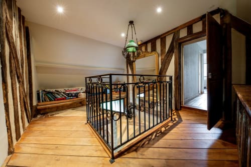 Chambre mansardée avec lit en fer forgé, poutres apparentes et vue sur mer à la villa La Girelle à Honfleur
