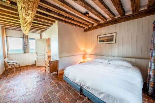 Chambre spacieuse de la villa La Girelle à Honfleur avec poutres apparentes, vue sur mer et accès direct à la plage
