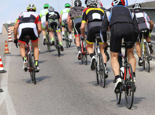 Groupe de cyclistes roulant sur une route près de Jausiers, en France, lors d'un événement ou d'une tournée cycliste.