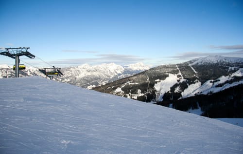 Piste de ski enneigée aux Chalets Cocody avec vue sur les montagnes et téléphérique à Jausiers