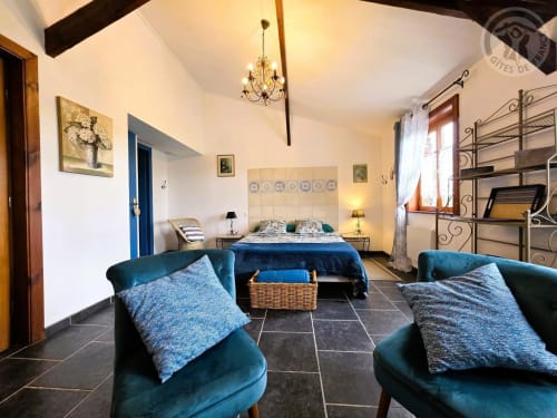 Spacieuse chambre à Ferme de la Forterie avec fauteuils bleus, lit queen-size et décor élégant à Verlinghem