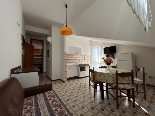 Open-plan apartment at Anthea hotel in Lignano Sabbiadoro with dining area, kitchen, living room, and garden view