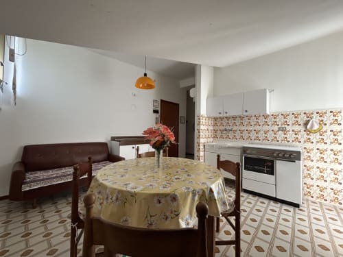 Open-plan kitchen and dining area at Villa Loris in Lignano Sabbiadoro with floral accents
