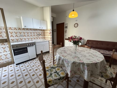 Villa Loris 2 kitchen-dining room at Anthea hotel, Lignano Sabbiadoro, with floral decor and round table