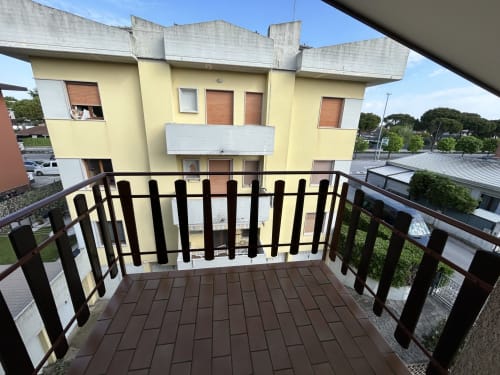 Balcony with black railing overlooking yellow villa at Anthea hotel, Lignano Sabbiadoro
