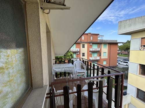 Balcony with white chairs and city view at Anthea hotel, Lignano Sabbiadoro