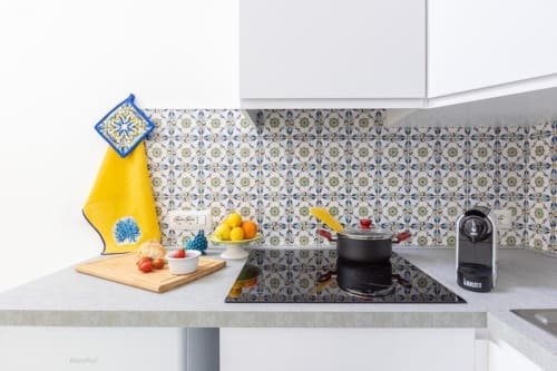 Cucina moderna di Appartamenti Momi Sorrento con piastrelle decorate, elettrodomestici e prodotti freschi sul bancone