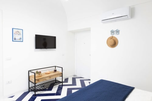 Appartamento Sealand Lobra presso Appartamenti Momi a Sorrento, con moderna camera da letto, tappeto chevron blu e arredamento minimalista