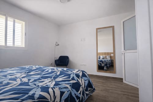 Bright bedroom in Apartamento Severo 3 at Alojamientos vacacionales en La Aldea with blue patterned bedding, mirror,