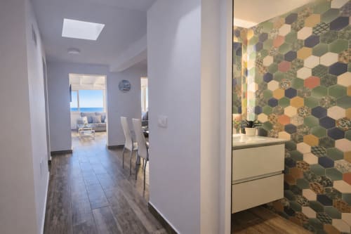 Modern hallway in Apartamento Severo 3 with hexagonal tile bathroom and ocean view through living area window, La Aldea