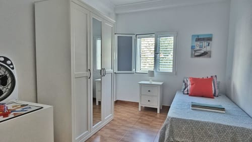 Bright bedroom in Apartamento Galoponte, La Aldea with single bed, white wardrobe, desk, and city views