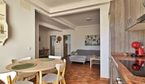 Modern apartment in La Aldea with dining table, kitchen, living area, and gray sofa with city views