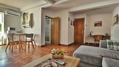 Galoponte apartment living area with wood floors, dining table, sofa, and kitchenette in La Aldea