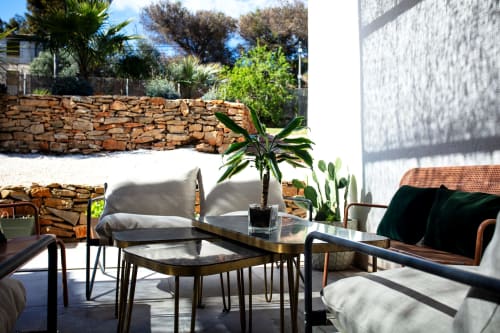 Outdoor terrace at Locavilla villa with seating area, stone walls, and lush Mediterranean garden views in Colombes