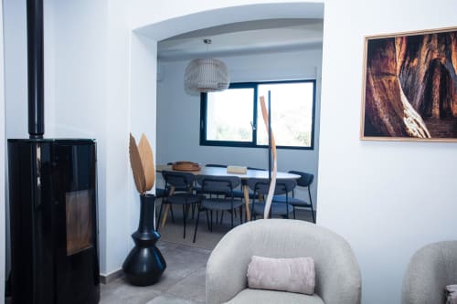 Modern villa interior at Locavilla Colombes with fireplace, grey armchair, dining area and pool view windows