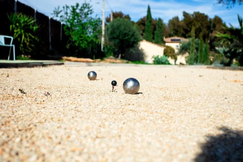 Pétanque balls on sandy court at Locavilla villa in Colombes, France with garden view