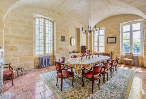 Salle à manger historique à la Conciergerie Maurin, Arles : voûtes en pierre, table ronde et fenêtres cintrées panoramiques