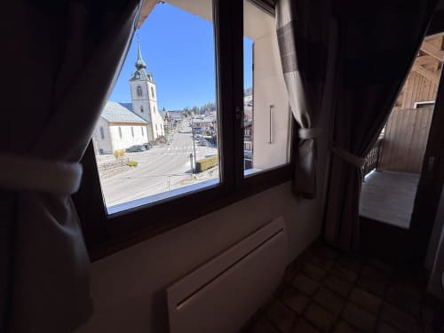 View from Studio Aravis window toward Notre Dame de Bellecombe village church and Alpine landscape