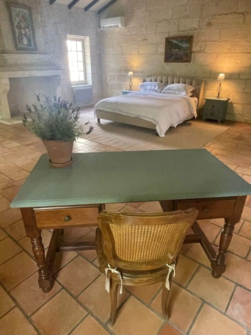 Chambre rustique à la Conciergerie Maurin, Arles : murs en pierre, bureau, lavande en pot et lit avec vue sur le jardin