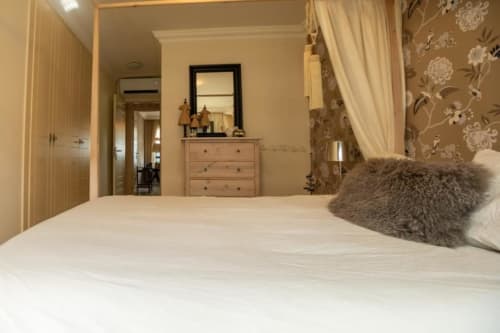 Modernes Schlafzimmer in der Residencial Anaga Wohnung, Santa Cruz de Tenerife, mit weißem Bett, grauem Kissen, hölzernem Kommode und