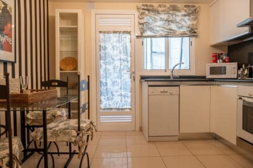 Moderne Küche und Essbereich im Residencial Anaga, Santa Cruz de Tenerife, mit cremefarbenen Schränken und Esstisch