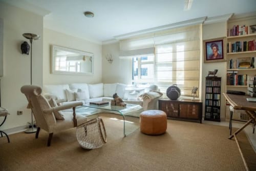 Helles Wohnzimmer in der Residencial Anaga Wohnung, Santa Cruz de Tenerife, mit Sofa, Sessel, Bücherregal und Glastisch