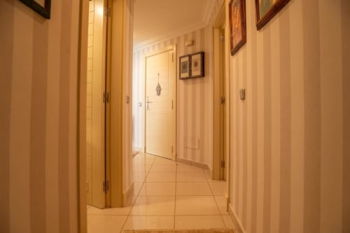 Heller Flur in Santa-Cruz-de-Tenerife-Apartment mit cremefarbenen Türen, Fliesenbelag und Wandbildern