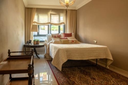 Helles, modernes Schlafzimmer in der Residencial Anaga mit Queensize-Bett, Fensterblick, Dekokissen und cremefarbener Einrichtung