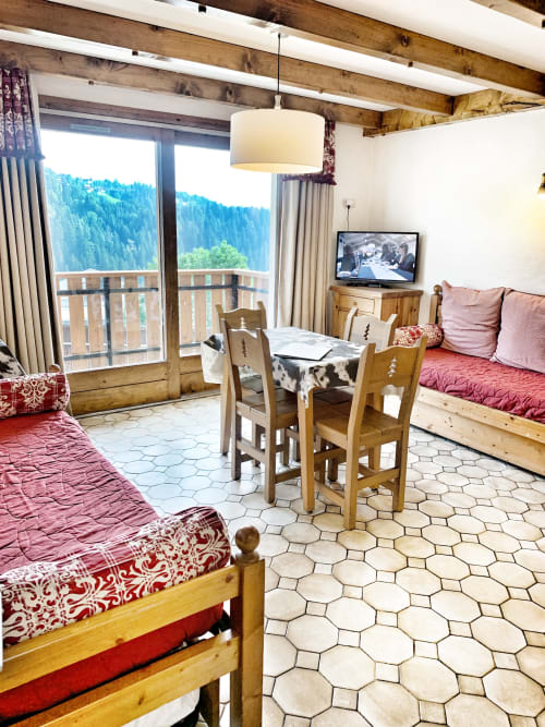 Studio Lachat apartment at Chez Francine with mountain views, wooden beams, twin beds, dining area, and balcony overlooking