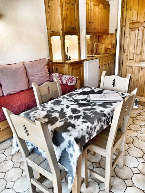 Studio Lachat apartment at Chez Francine with white wooden bed, cow print bedding, and rustic pine furnishings in Notre Dame