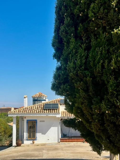 Villa rural Casa Finca El Olivar en Valencia con muros blancos, tejadillos de terracota y cipreses