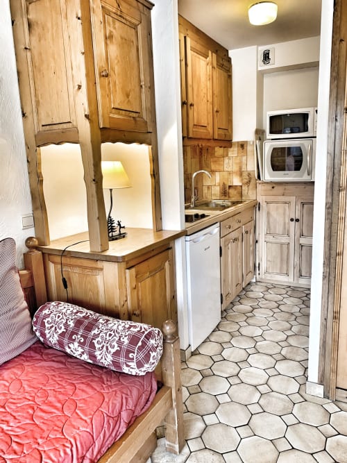 Studio Lachat apartment at Chez Francine with wooden cabinetry, kitchenette, and hexagonal tile flooring in Notre Dame de