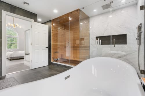 Luxury bathroom at Malkita Aria villa in Highland Mills featuring freestanding soaking tub, walk-in shower, and mountain