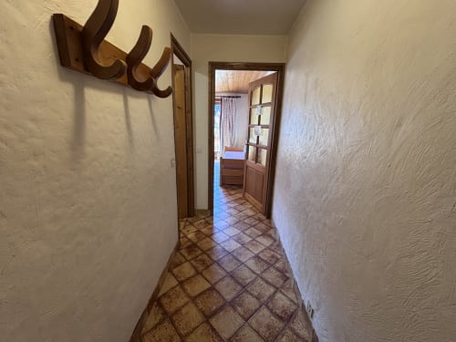Hallway with terracotta tiles and wooden coat rack at Chez Francine studio apartment, Notre Dame de Bellecombe