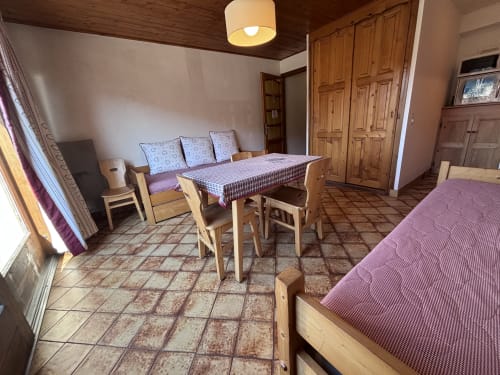 Studio Ban rouge apartment at Chez Francine with wooden furniture, beds, dining table, and terracotta tile flooring