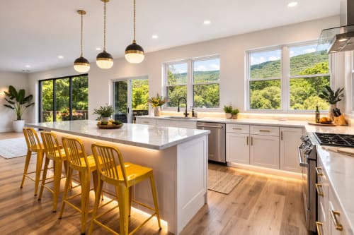 Modern kitchen with mountain views, white cabinetry, yellow bar stools, pendant lighting, and stainless steel appliances in