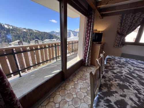 Bright mountain view from Appartement Mont Rond balcony in Notre Dame de Bellecombe, showing snowy Alps and forested slopes