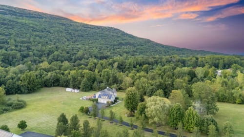 Malkita Terra villa in Highland Mills with mountain views, set among lush green forests and manicured grounds at sunset.