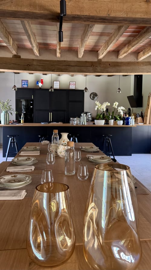 Le hall de réception élégant de Cloffy à Nouans-les-Fontaines avec poutres apparentes, cuisine noire et mise en place formelle