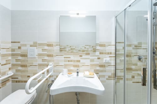 Moderno bagno della Torre dei Venti B&B a Ceccano con rivestimento in piastrelle beige, lavabo bianco e box doccia in vetro