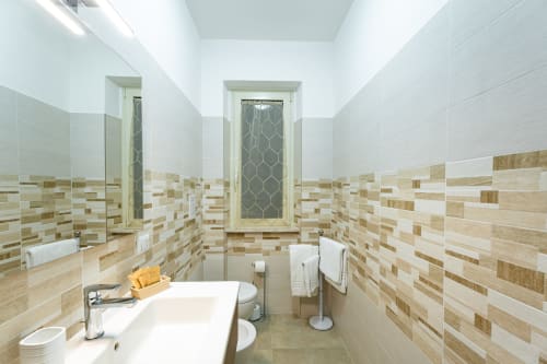 Modern bathroom in Camera Grecale at Torre dei Venti B&B, Ceccano with striped tile walls and sink