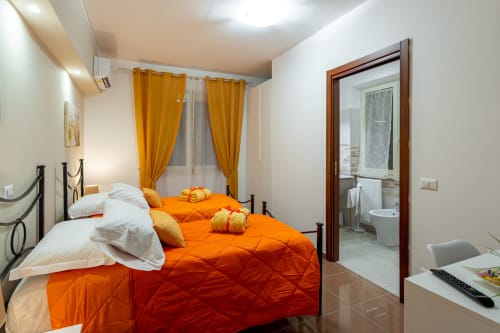 Camera Scirocco alla Torre dei Venti B&B di Ceccano con letti gemelli, biancheria arancione e bagno ensuite