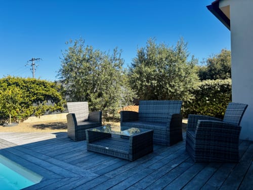 Blue wicker furniture and glass table on wooden deck by pool at Belle villa Amanduli, Zilia