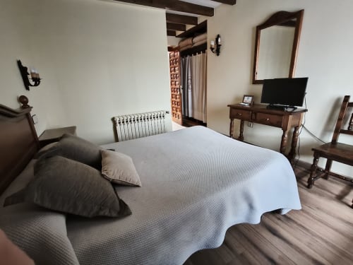 Spacious double bedroom at Posada La Colodra with TV, desk, and mountain views in Spain