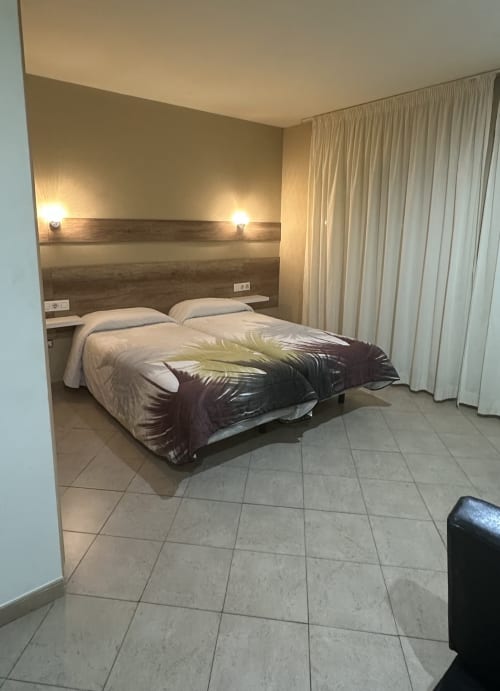 Triple Standard apartment bedroom at Raquel's in Sant Pere Pescador with two beds, wooden headboard, wall sconces, and