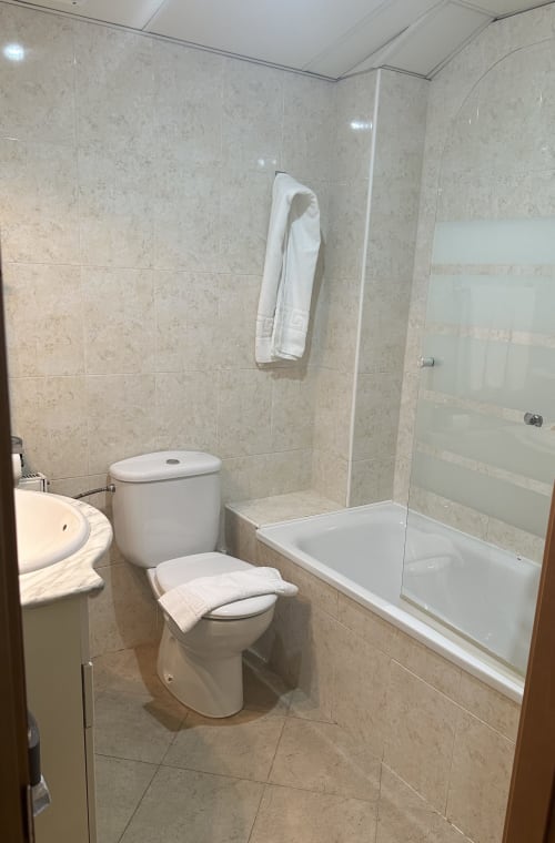 Modern bathroom with toilet, sink, and shower enclosure at Apartamentos Turisticos Raquel's in Sant Pere Pescador