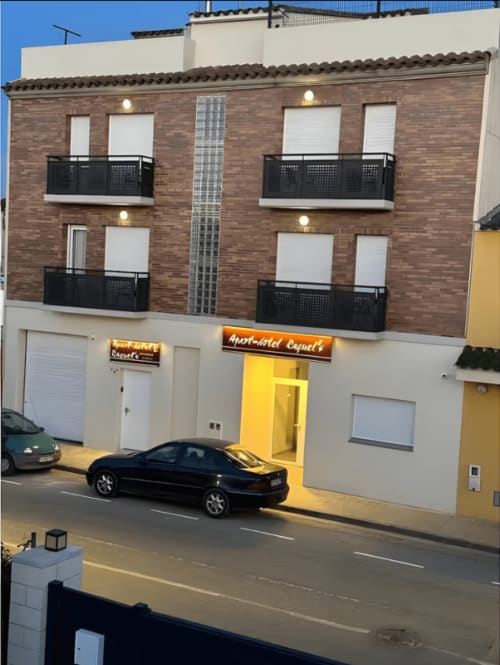 Apartamentos Turísticos Raquel's exterior at dusk, Sant Pere Pescador with yellow entrance and black balconies